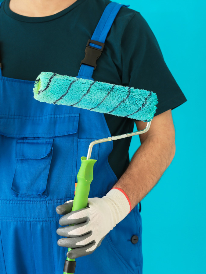 Infográfico contendo a fotografia de um pintor segurando um rolo de pintura sujo com tinha azul, com parede azul ao fundo. 