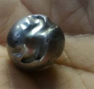 Fotografia da esfera da válvula de admissão do equipamento airless bastante deformada.