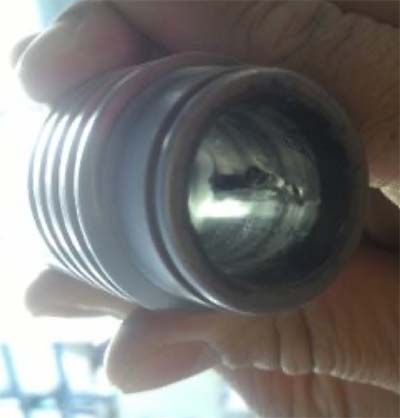 Fotografia do assento da esfera da válvula de admissão do equipamento airless bastante deformado.