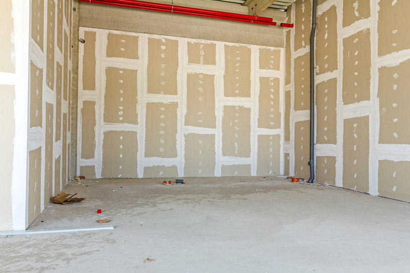 Fotografia de um cômodo que receberá o drywall. É possível identificar as estruturas cartonadas nas três paredes (laterais e de fundo).
